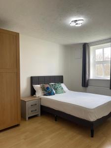 Schlafzimmer mit einem Bett und einem Fenster in der Unterkunft 2Bed Cozy Spacious apartment - 15min to Canary Wharf O2 Excel Central London in London