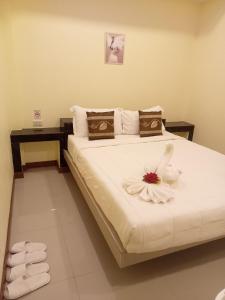 a bedroom with a bed with a flower on it at ไลอ้อน โฮเทล in Chumphon