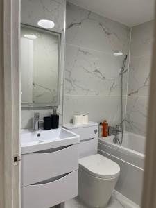 La salle de bains blanche est pourvue de toilettes et d'un lavabo. dans l'établissement 2Bed Cozy Spacious apartment - 15min to Canary Wharf O2 Excel Central London, à Londres