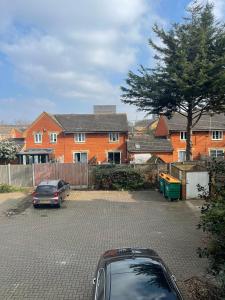a car parked in a parking lot in front of a house at 2Bed Cozy Spacious apartment - 15min to Canary Wharf O2 Excel Central London in London