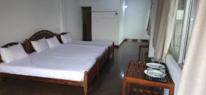 a bedroom with two beds and a table and a window at Oyado Marufuku in Kandy