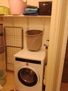 a washing machine with a basket on a shelf at CASA Mama total in Bodø