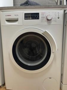 a white washing machine sitting in a kitchen at 2Bed Cozy Spacious apartment - 15min to Canary Wharf O2 Excel Central London in London