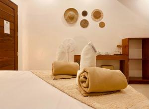 een slaapkamer met een bed met een kussen en een ventilator bij General's Hideout Siargao in General Luna