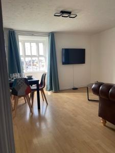 a living room with a table and a television at 2Bed Cozy Spacious apartment - 15min to Canary Wharf O2 Excel Central London in London