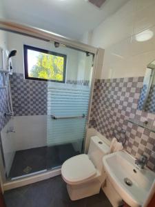 a bathroom with a shower and a toilet and a sink at Mango Prima in Moalboal