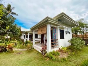 a small white house with a mural on it at General's Hideout Siargao in General Luna