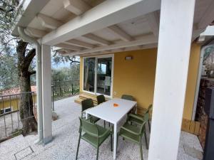 eine Terrasse mit einem weißen Tisch und Stühlen in der Unterkunft Camping Le Maior in Brenzone sul Garda