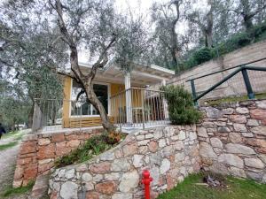 ein gelbes Haus mit einer Steinmauer und einem roten Hydranten in der Unterkunft Camping Le Maior in Brenzone sul Garda