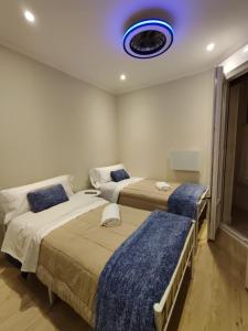 a bedroom with two beds and a blue light on the ceiling at CENTRAL ROOM in Bilbao