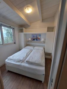 ein Schlafzimmer mit einem Bett in einem kleinen Zimmer in der Unterkunft Camping Le Maior in Brenzone sul Garda