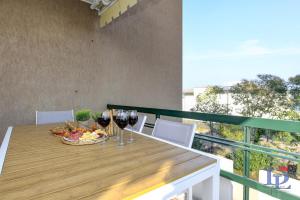 a table with glasses of wine and a bowl of fruit at Marriott Imperium DesenzanoLoft Official Partner Homes & Villas by Marriott Bonvoy in Desenzano del Garda +45 photos