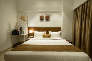 a bedroom with a large bed with white sheets at Freesia Residency By Express Inn - Navi Mumbai in Navi Mumbai
