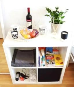 a white table with a plate of fruit and a bottle of wine at Great central premium 1 BR apartment in best area 10117 Berlin Mitte, Leipziger Straße in Berlin