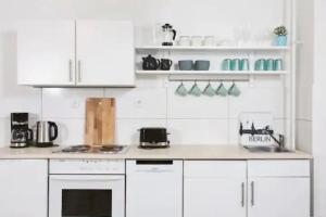 a kitchen with white cabinets and a counter top at Great central premium 1 BR apartment in best area 10117 Berlin Mitte, Leipziger Straße in Berlin