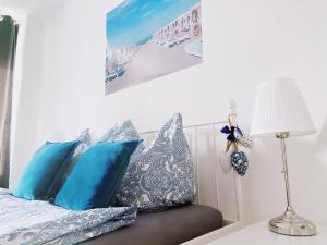 a bedroom with a bed with blue pillows and a lamp at Great central premium 1 BR apartment in best area 10117 Berlin Mitte, Leipziger Straße in Berlin