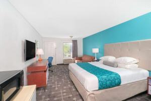 a hotel room with a large bed and a flat screen tv at Howard Johnson by Wyndham Aiken in Aiken