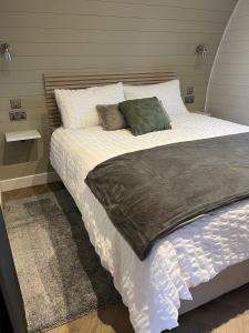欣克利的住宿－The Pod @ Cold Comfort Farm，卧室配有一张带白色床单和枕头的大床。