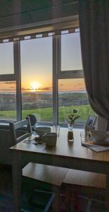 einen Tisch mit Blick auf den Sonnenuntergang von einem Fenster aus in der Unterkunft Sea Crest B&B Rossnowlagh in Rossnowlagh