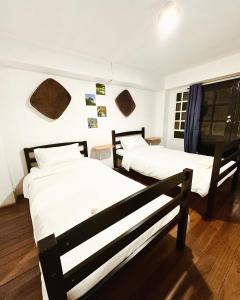 Habitación con 2 camas y ventana en Sefernia Tranquil Abode, en Baguio