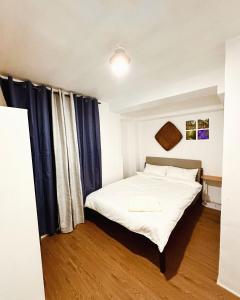1 dormitorio con cama blanca y cortinas azules en Sefernia Tranquil Abode, en Baguio