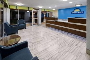 a lobby with chairs and a table and a desk at Days Inn by Wyndham Forsyth in Forsyth +19 photos