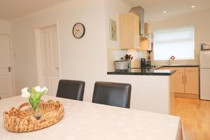 a kitchen with a table with a bowl of flowers on it at 7 BAYS for 7 DAYS! Spacious bungalow near 7 beaches in Saint Merryn