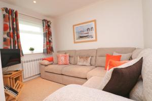 a living room with a couch and a tv at 7 BAYS for 7 DAYS! Spacious bungalow near 7 beaches in St Merryn