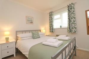 a bedroom with two beds and a window at 7 BAYS for 7 DAYS! Spacious bungalow near 7 beaches in St Merryn