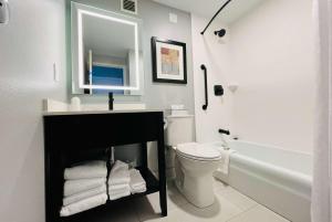 a bathroom with a sink and a toilet and a mirror at Hawthorn Extended Stay by Wyndham Ellsworth Bar Harbor in Ellsworth