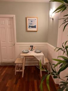 a dining room table with two plates on it at Contented Cottage - 2 Bedrooms, Zone 5 in Buckhurst Hill