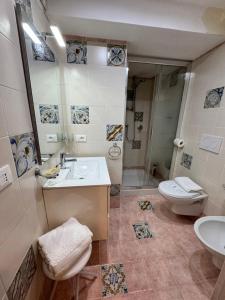 La salle de bains est pourvue d'un lavabo et de toilettes. dans l'établissement Taormina's sun apartment, à Taormine