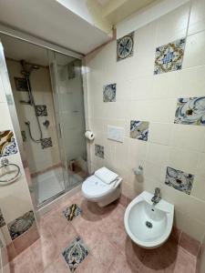La salle de bains est pourvue de toilettes, d'une douche et d'un lavabo. dans l'établissement Taormina's sun apartment, à Taormine