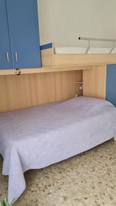 un letto in una camera con lenzuola bianche di Luce a Pescara