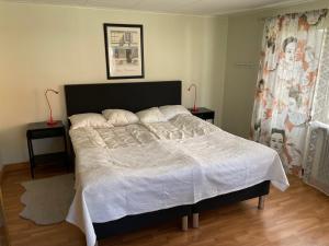 ein Schlafzimmer mit einem Bett mit einer weißen Bettdecke in der Unterkunft Naturskönt boende vid Sjö in Skånes Fagerhult