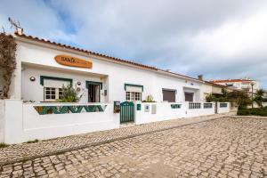 a white building with a cobblestone street in front at Santa, Sea & Sun in Santa Cruz