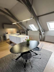 um quarto com uma mesa e cadeiras num sótão em Loft @ de Vlaamse Ardennen em Brakel