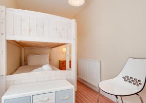 克羅默的住宿－No.3 Jetty Street，客房内的白色双层床和白色椅子
