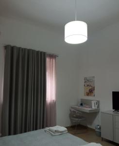 een slaapkamer met een bed en een raam met een bureau bij Suite Europa in San Vito dei Normanni