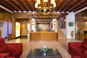 een lobby met rode banken en een rechtszaal bij Hotel La Carolina in Lloret de Mar