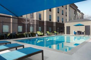 a swimming pool with chairs and a building at Hampton Inn & Suites El Paso/East in El Paso