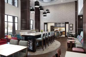 a restaurant with a bar with chairs and tables at Hampton Inn & Suites El Paso/East in El Paso