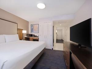 a hotel room with a bed and a flat screen tv at Embassy Suites Chicago - Downtown River North in Chicago