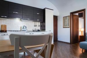 una cocina con armarios negros y una mesa en una habitación en Le Rupi - Apartment, en Anguillara Sabazia
