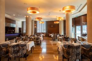 una sala da pranzo con tavoli, sedie e luci di DoubleTree by Hilton Bratislava a Bratislava