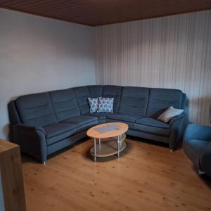 - un salon avec un canapé bleu et une table dans l'établissement Schöne große Wohnung - 4Family, à Rodgau