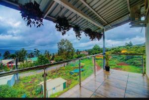 a balcony of a house with a view of a hill at OCEAN CREST LUXURY VILLA Mahabaleshwar in Mahabaleshwar