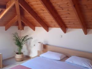 a bedroom with a white bed and a potted plant at Kritikos Rooms in Monemvasia