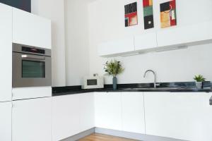 a kitchen with white cabinets and a sink at Luxury, Spacious 2 Bed flat in London in London