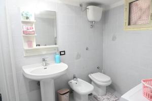 a white bathroom with a sink and a toilet at Big House near the Station in Torre Annunziata +7 photos